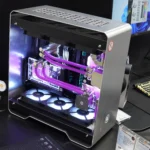 Hình ảnh bộ PC custom với vỏ kim loại màu bạc và tản nhiệt nước, minh họa cho sự phức tạp và đầu tư vào phần cứng máy tính