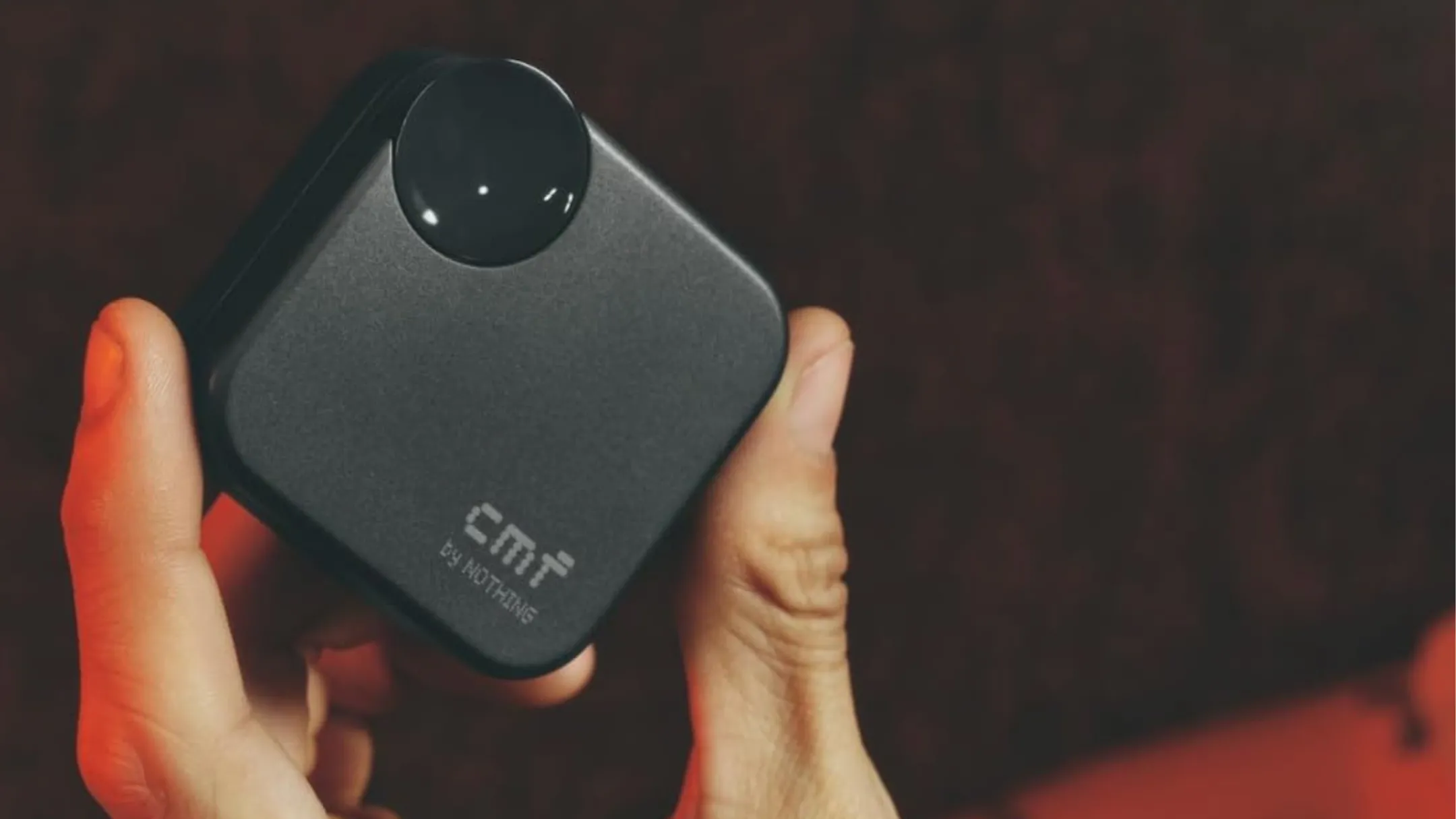 Hộp sạc và tai nghe không dây CMF Buds 2a màu đen đặt trên nền màu cam