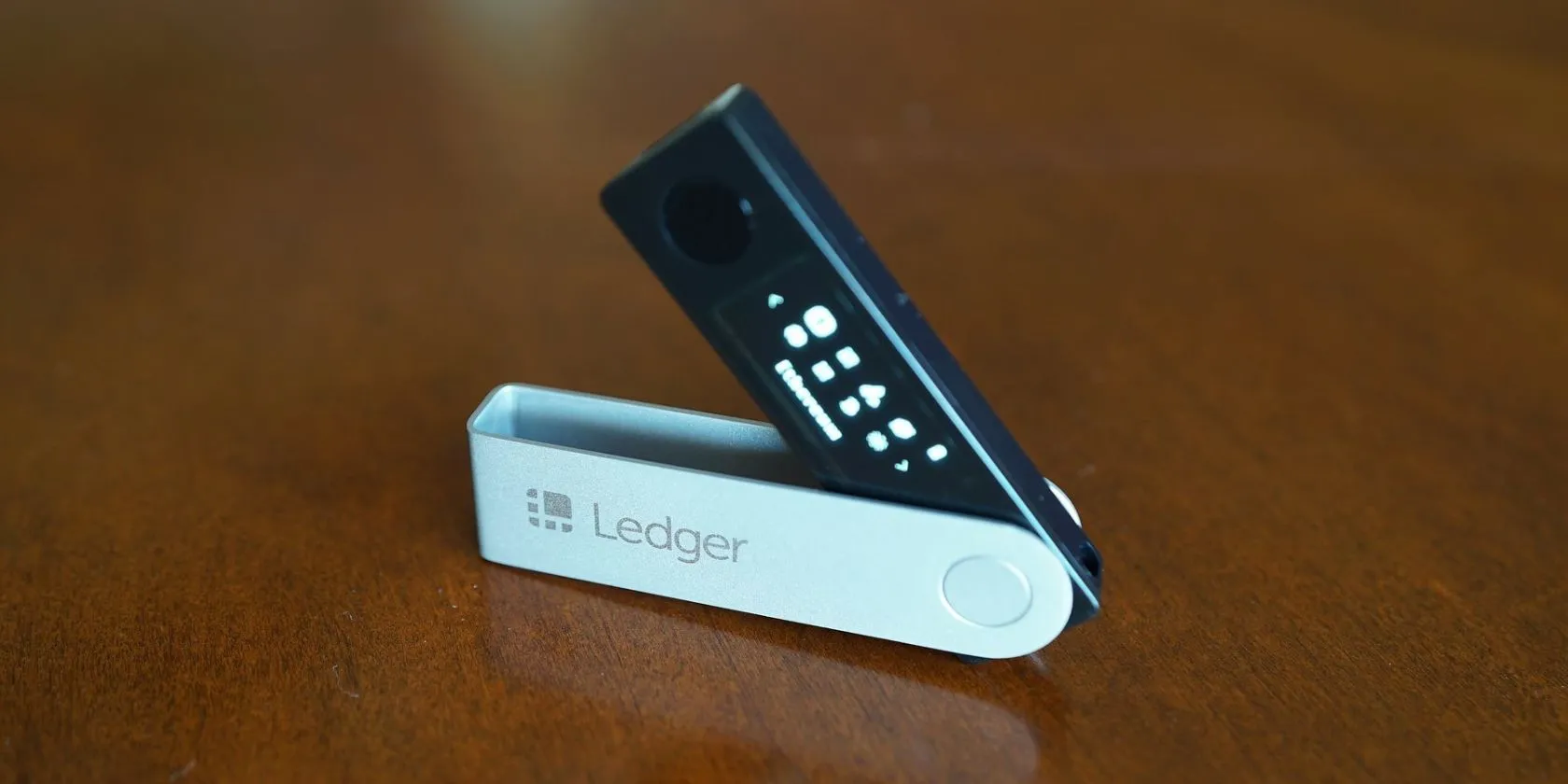 Thiết bị ví lạnh Ledger Nano X trên bề mặt gỗ, tăng cường bảo mật tiền điện tử.