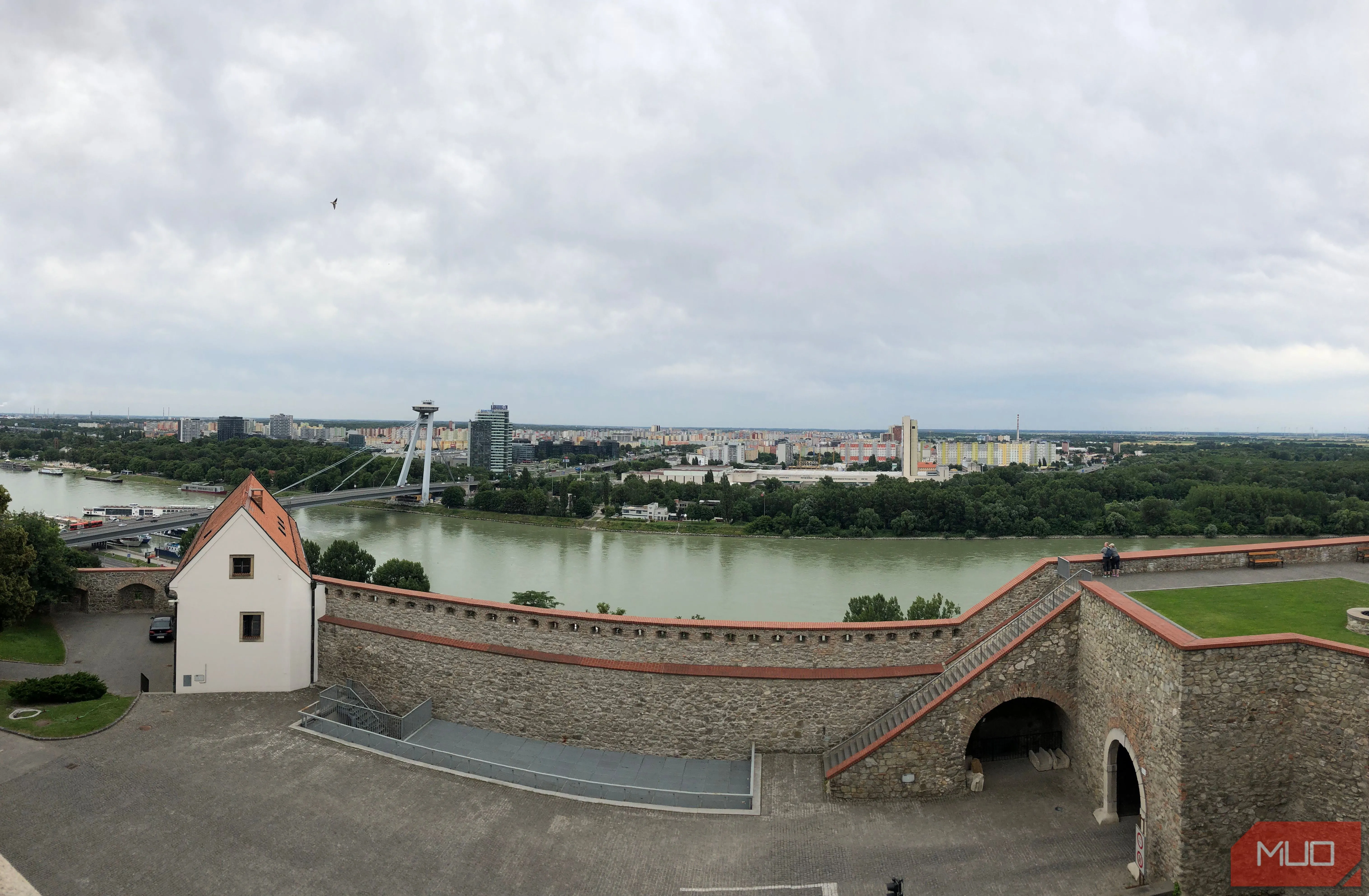 Ảnh panorama thành phố và sông nhìn từ một lâu đài, sử dụng vòm kiến trúc làm khung hình độc đáo, minh họa việc tận dụng môi trường xung quanh để tạo điểm nhấn cho bức ảnh.