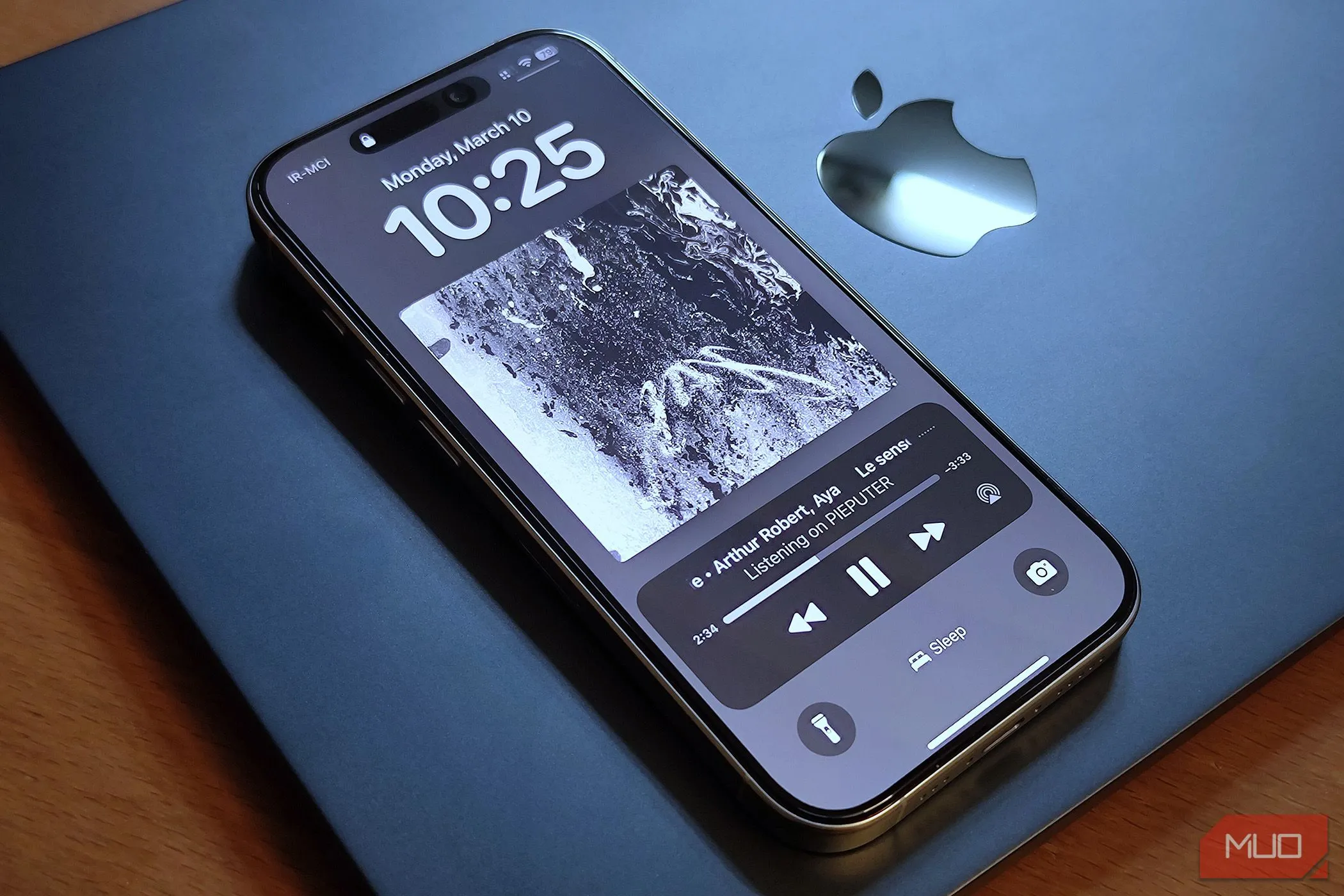 Chiếc điện thoại iPhone 16 Pro được đặt trên máy tính xách tay MacBook Air
