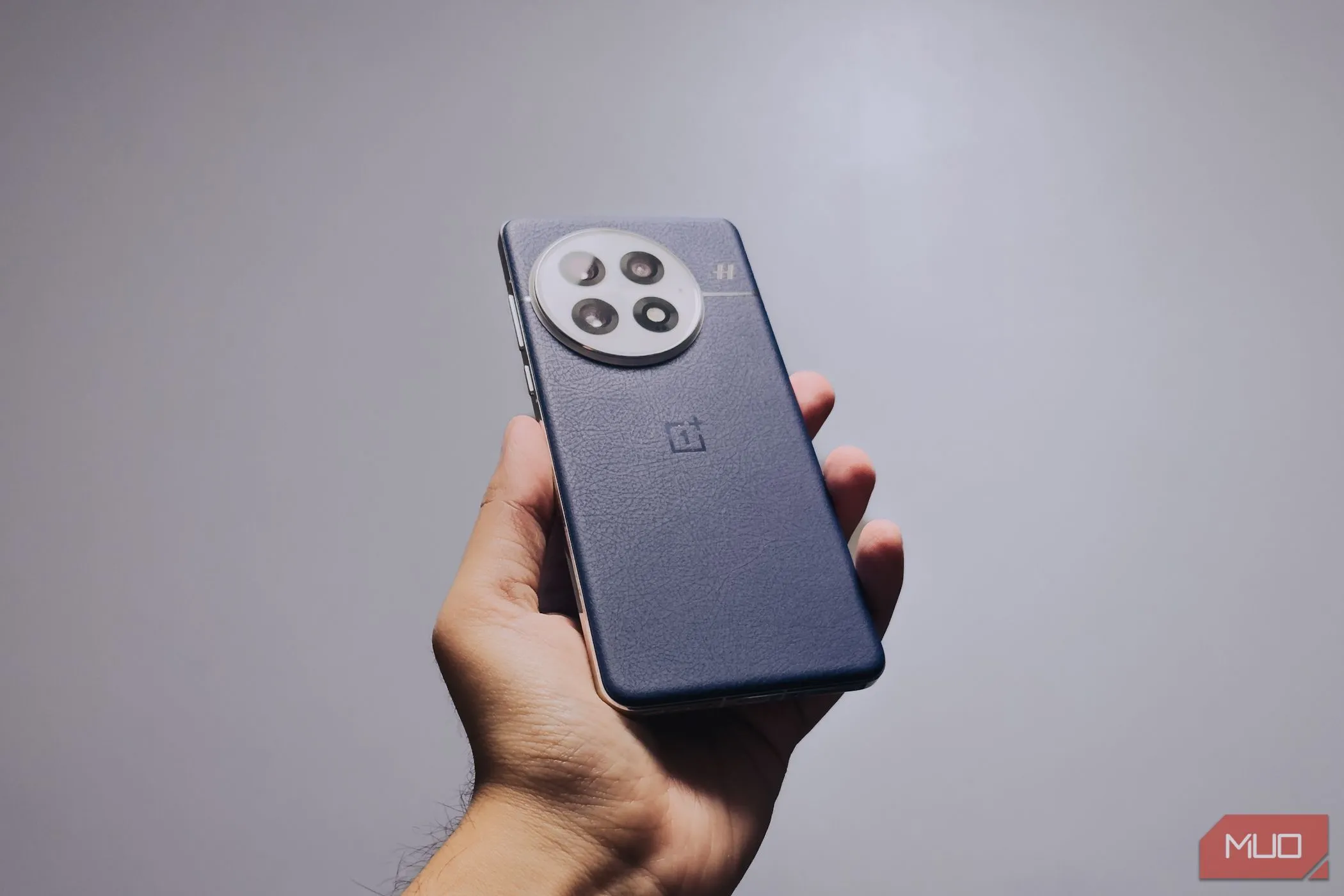 Hình ảnh OnePlus 13 trên tay người dùng, thể hiện góc cạnh và mặt lưng da cải thiện độ bám