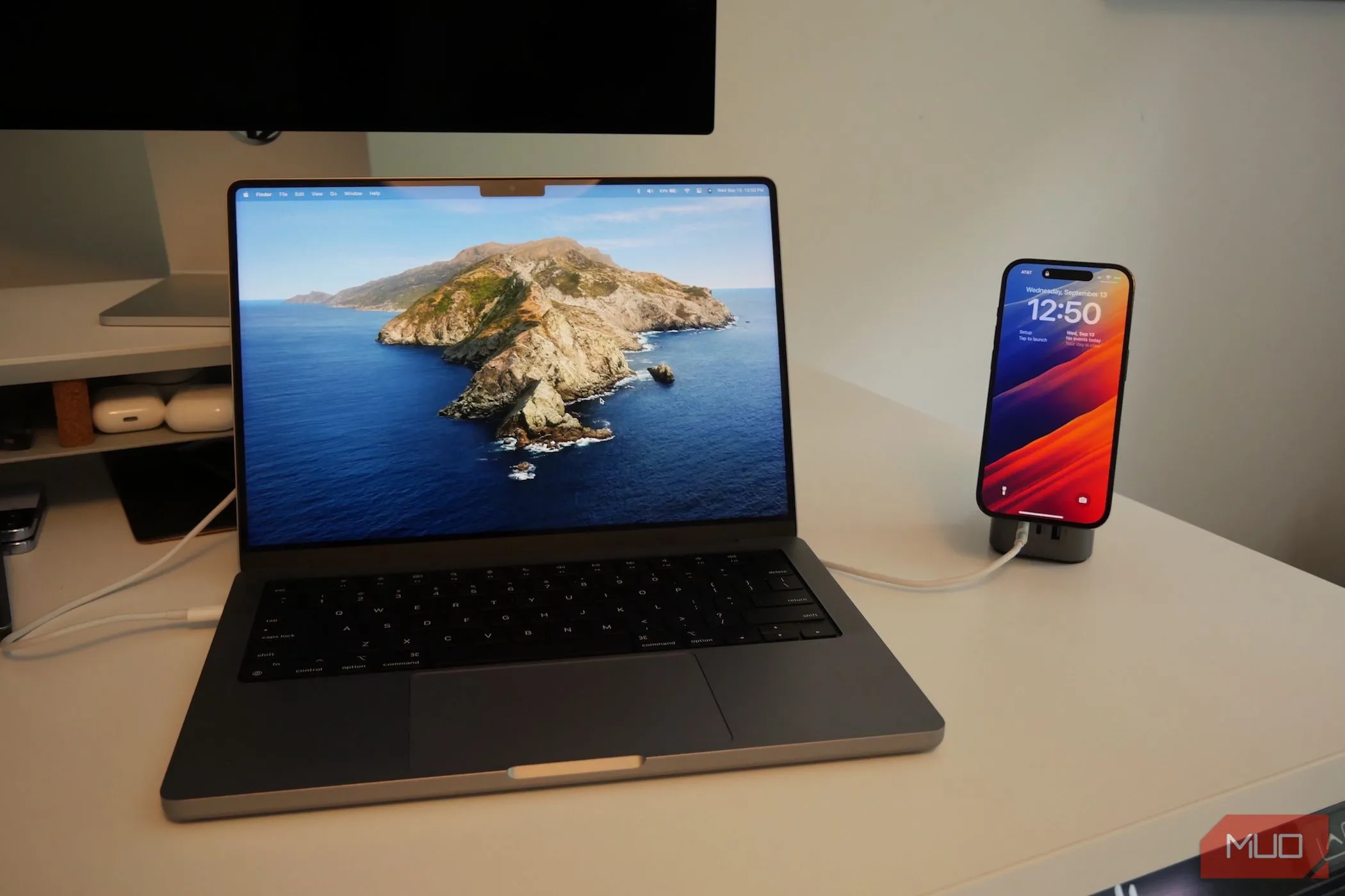 MacBook Pro và iPhone đang sạc trên bàn