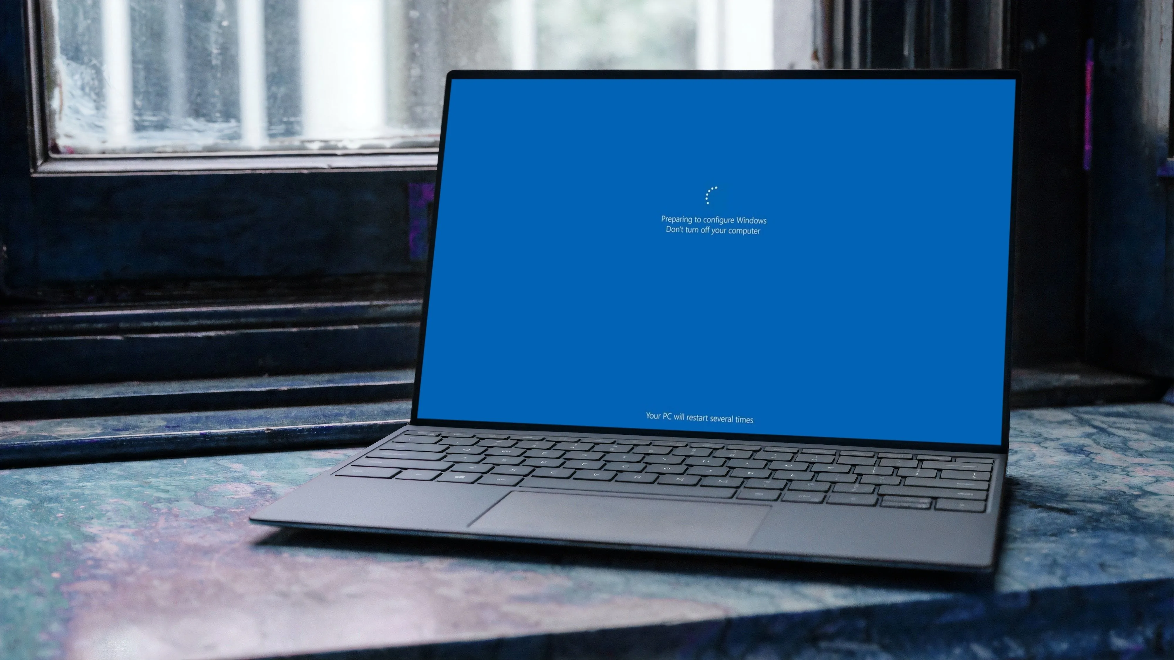 Máy tính xách tay chạy Windows 11 đang cài đặt các bản cập nhật hệ thống, màn hình hiển thị thông báo &quot;Please wait&quot;