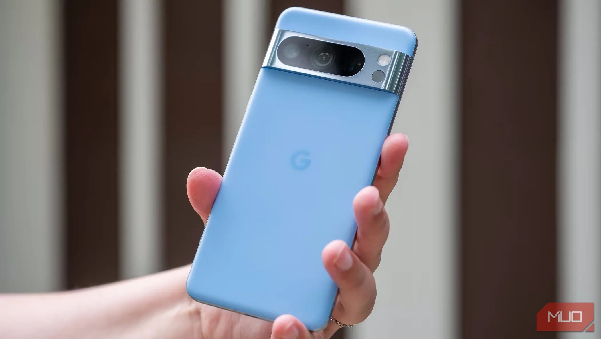 Một người đàn ông đang cầm điện thoại Pixel 8 Pro và đưa lưng máy lên phía trước