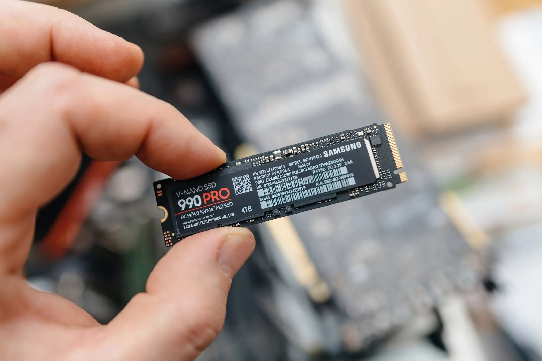 Người đàn ông đang cầm ổ cứng SSD Samsung 990 Pro, biểu tượng của hiệu suất lưu trữ hiện đại