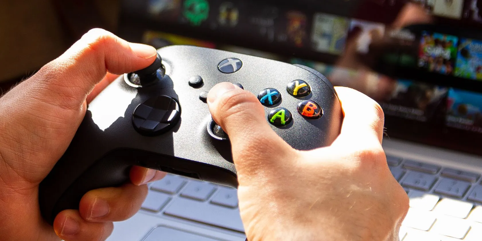 Người đàn ông đang sử dụng tay cầm Xbox kết nối với laptop Chromebook để chơi game