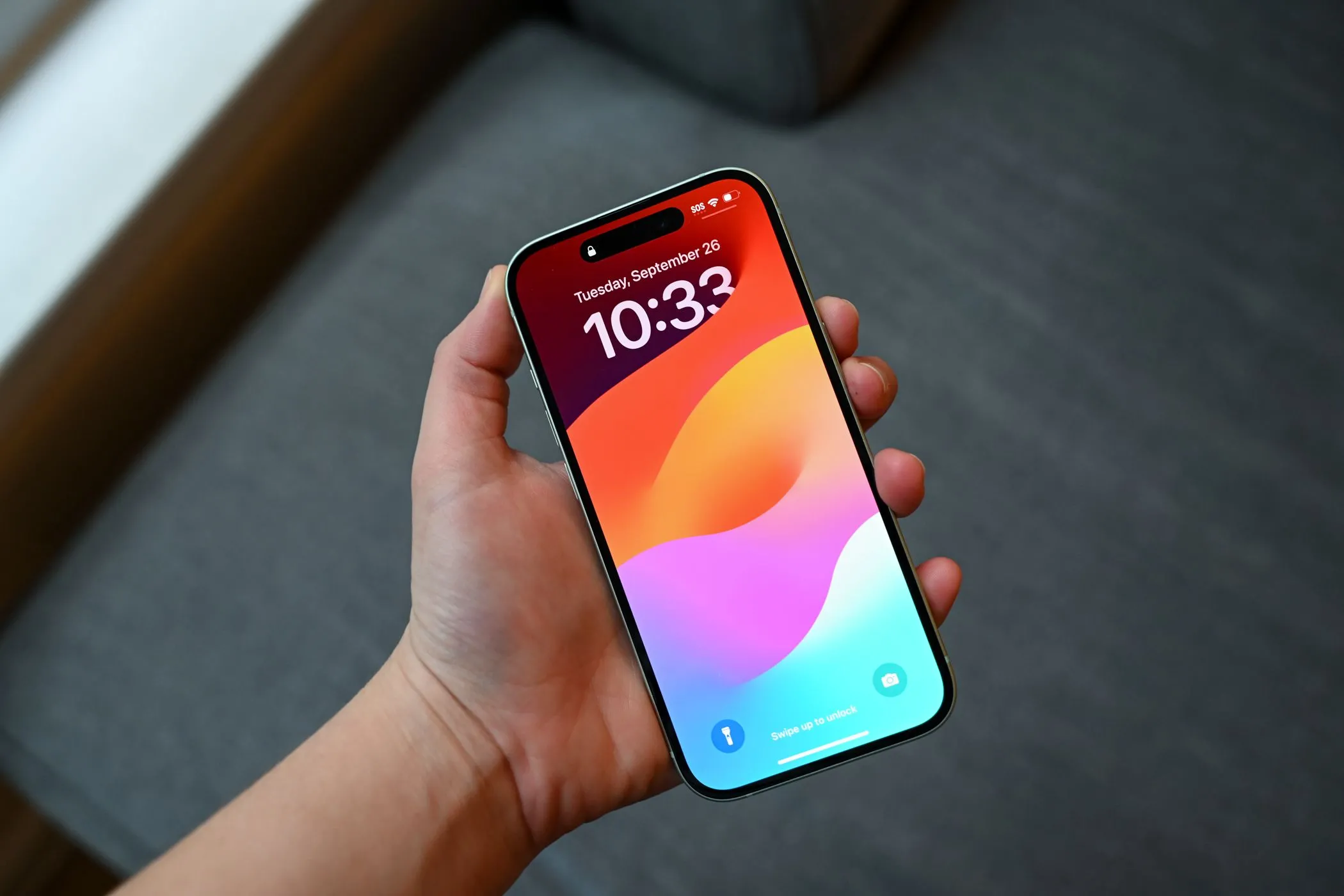 Người dùng cầm iPhone 15 đang hiển thị màn hình khóa, minh họa khả năng miếng dán chống nhìn trộm giúp che đi các vết trầy xước nhỏ trên màn hình cũ, làm thiết bị trông mới hơn.
