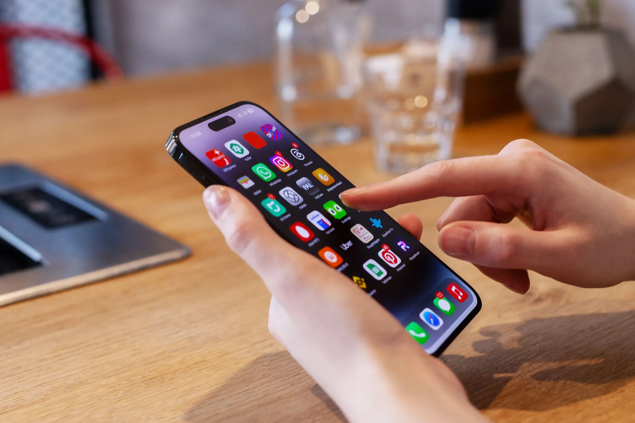 Người dùng đang tương tác với chiếc iPhone, nhấn mạnh việc thiếu tính năng lưu nguồn ảnh chụp màn hình