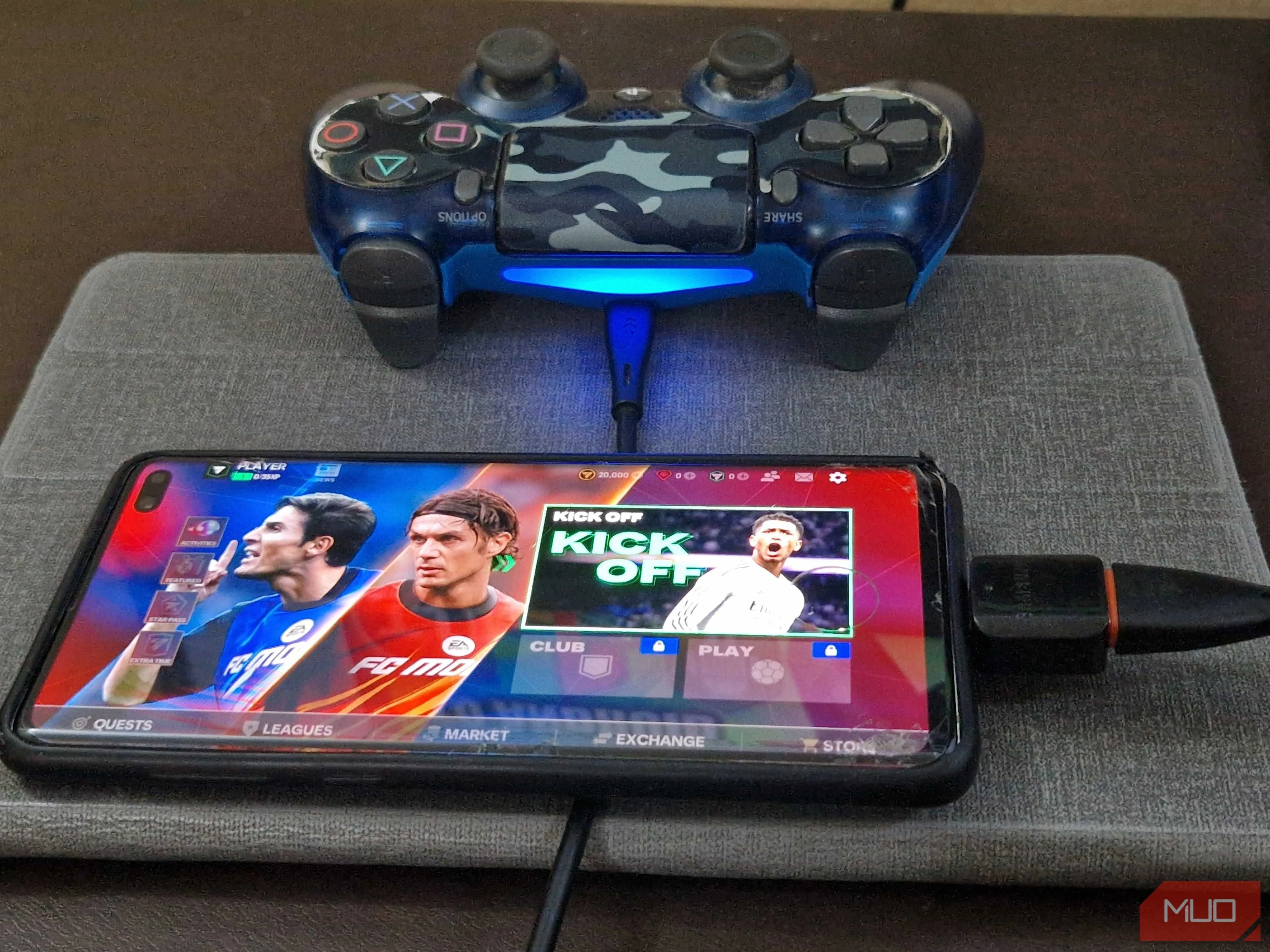 Tay cầm chơi game PS4 được kết nối với điện thoại thông minh qua bộ chuyển đổi OTG và cáp USB.